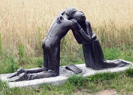 Das Bild zeigt eine Statue von zwei Menschen, die sich umarmen. Das Werk heisst Denkmal der Versöhnung. Es steht bei der Kapelle der Versöhnung in Berlin.s und stehehdd hnmar aus B