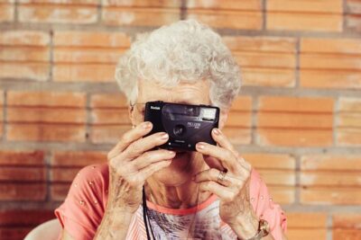 Eine ältere Dame fotografiert und freut sich darüber