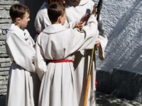 4 Ministranten betrachten das Prozessionskreuz